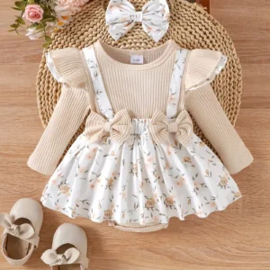 Baby girl outfit set with cream ribbed top, floral suspender skirt, matching headband bow, and beige shoes with bows, arranged on wooden surface.