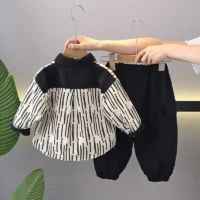 Boys black and white two‑piece outfit with long‑sleeve shirt and solid black pants, displayed for catalog