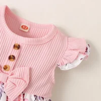 Baby girl floral dress set with ribbed bodice, waist bow, floral skirt, and matching headband, displayed for catalog.