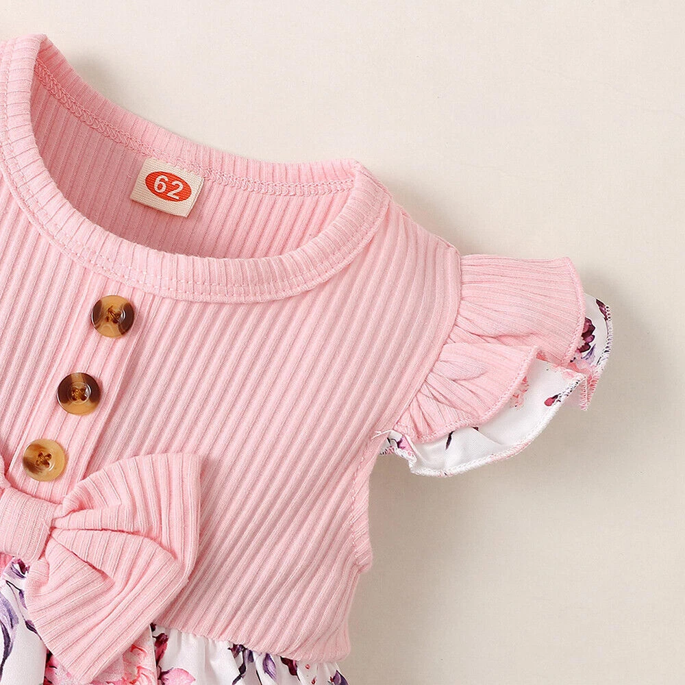 Baby girl floral dress set with ribbed bodice, waist bow, floral skirt, and matching headband, displayed for catalog.