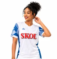 ChatGPT Image Apr 28, 2026, 12_06_22 PM (1) Woman modeling the official white and blue Rayon Sports FC away jersey with Skol logo – Tsapa Rwanda
