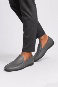 a man in Grey leather apron-toe moccasin loafers for men with crest emblem