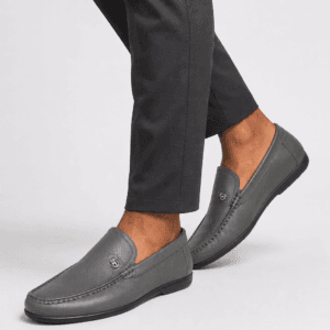 a man in Grey leather apron-toe moccasin loafers for men with crest emblem