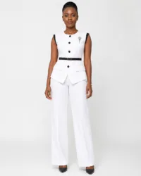 Woman wearing a white sleeveless peplum pantsuit with black trim and wide-leg trousers