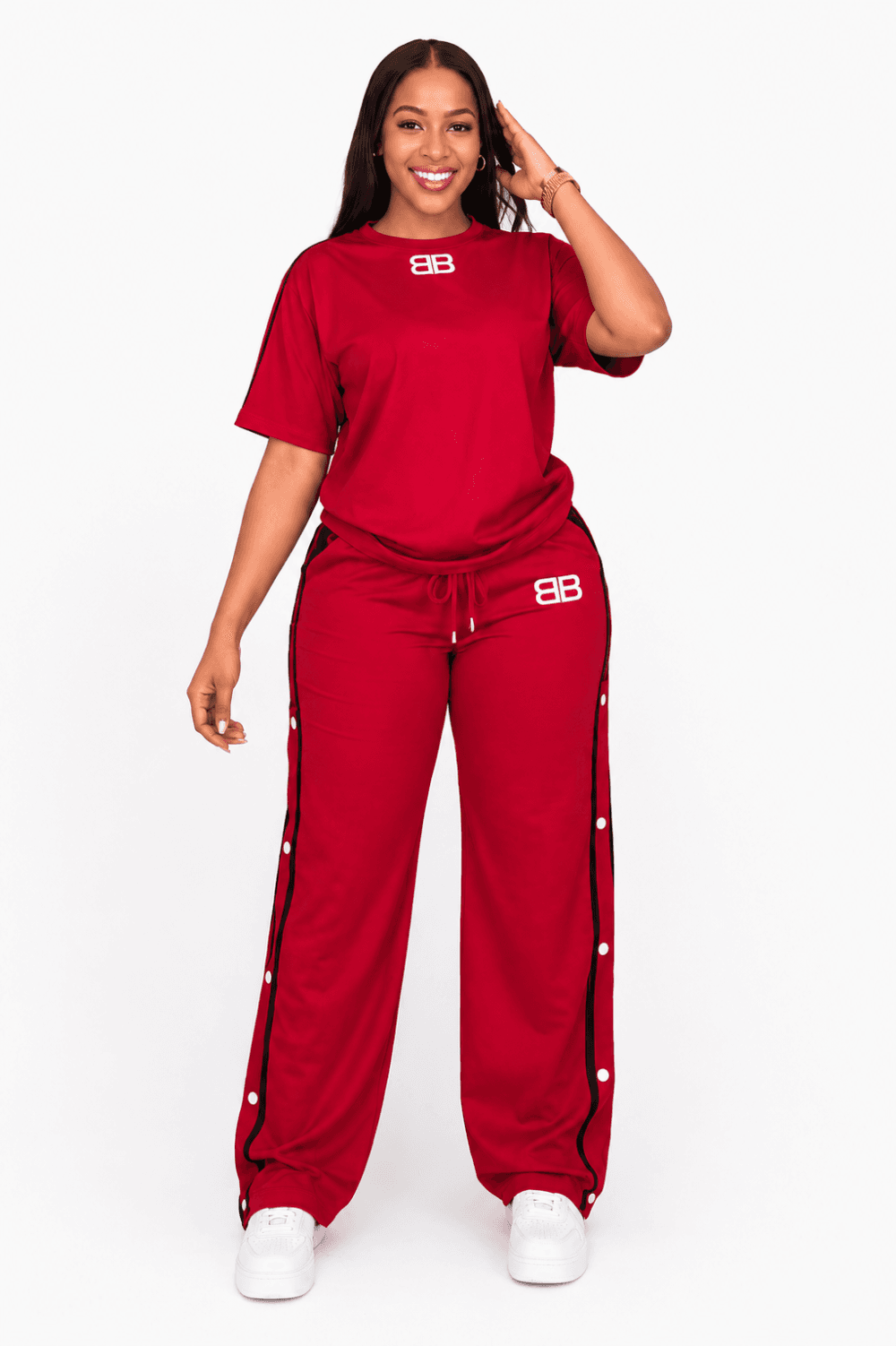 Women’s Red Side-Snap Tracksuit Set Woman wearing a red T-shirt and wide-leg side-snap track pants set