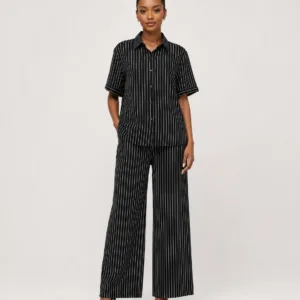 Full-length studio view of model wearing black pinstripe short-sleeve button-down shirt and wide-leg trousers set — Women's Fashion Rwanda.