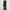 Full-length studio view of model wearing black short-sleeve MIU MIU shirt and wide-leg trousers two-piece set with red contrast trim and logo branding — Women's Fashion Rwanda.