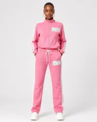Full-length front view of model wearing vibrant pink full-zip track jacket and matching track pants two-piece set with white stripes and MIU logo — Women's Fashion Rwanda.