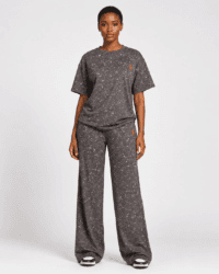 Full-length front view of model wearing charcoal grey acid wash oversized t-shirt and wide-leg sweatpants two-piece set with red logo — Women's Fashion Rwanda.